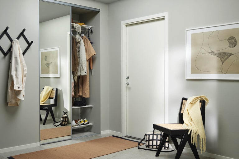 Hall med skjutdörrsgarderob, klädhängare och sittplats