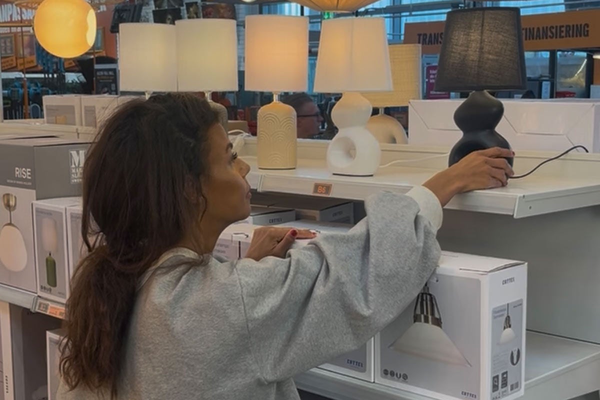 Kund som tittar på bordslampor i hyllan på Hornbach