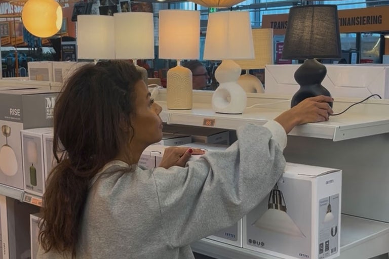 Kund som tittar på bordslampor i hyllan på Hornbach