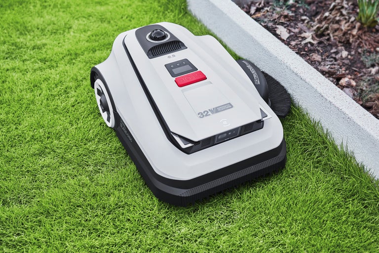 Robotgräsklippare på en gräsmatta som klipper med precision längs en rabattkant.