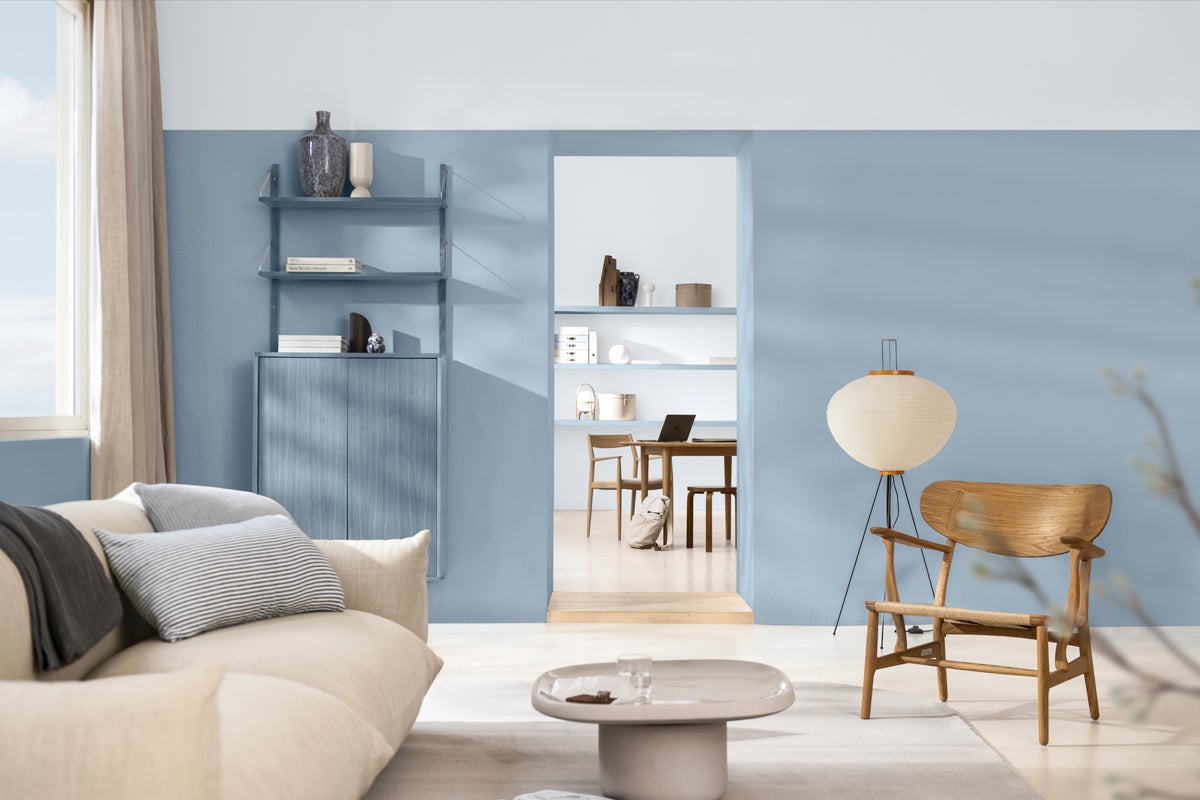 Ljust vardagsrum med soffa, bord, stol och hylla