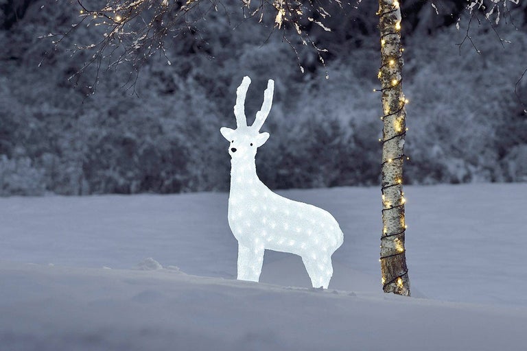 Belyst hjortfigur i vinterträdgård