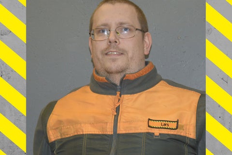 Porträtt av en man med glasögon och arbetsjacka