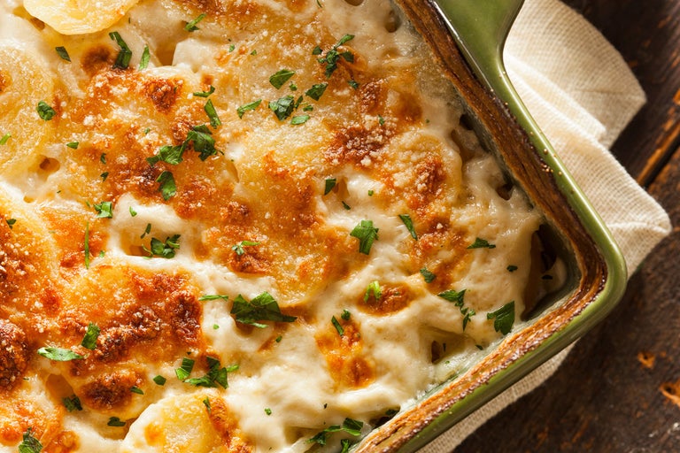 Gratängform med potatisgratäng, garnerad med persilja