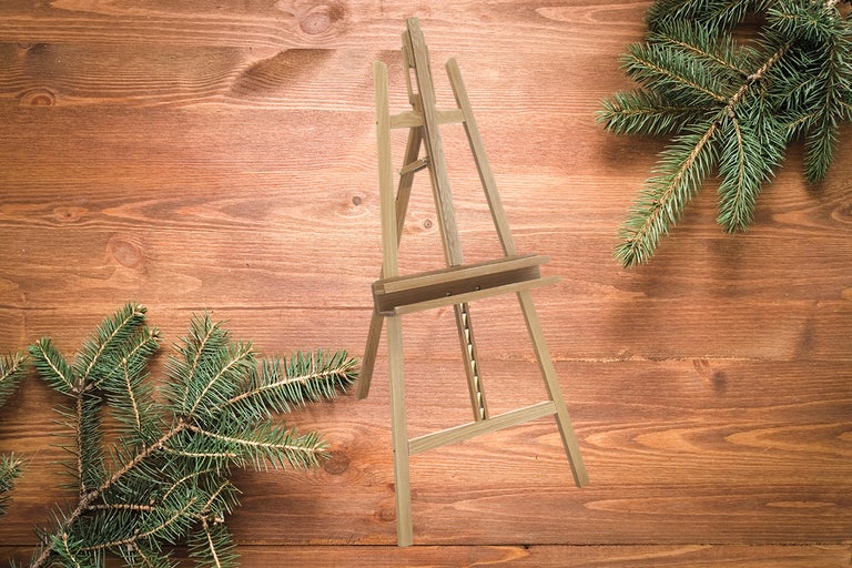 Trästaffli med julgranskvistar på träbord