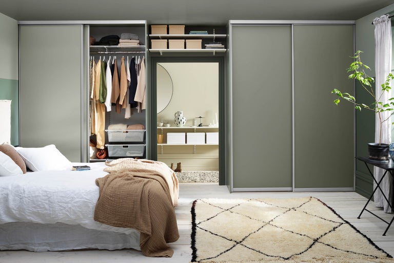 Sovrum med garderob med skjutdörrar, säng och matta