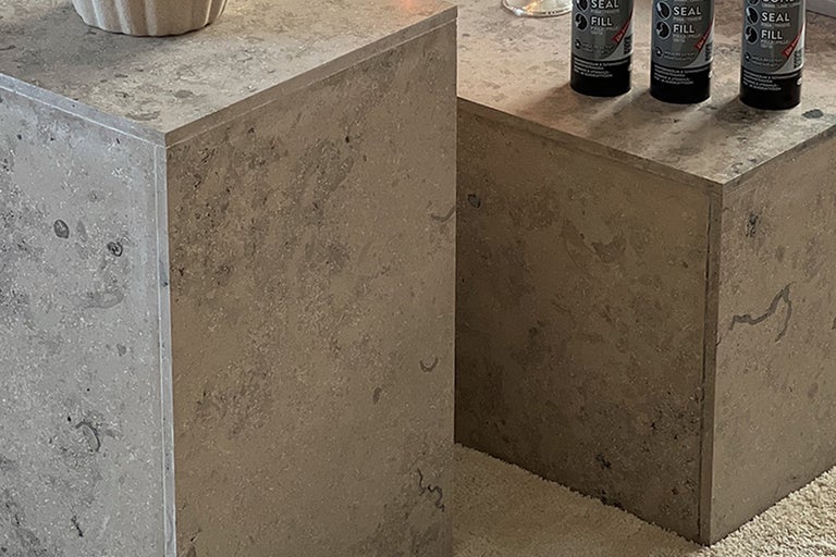 Närbild av två kubformade bord med oregelbunden yta och tre burkar med tätningsmedel.