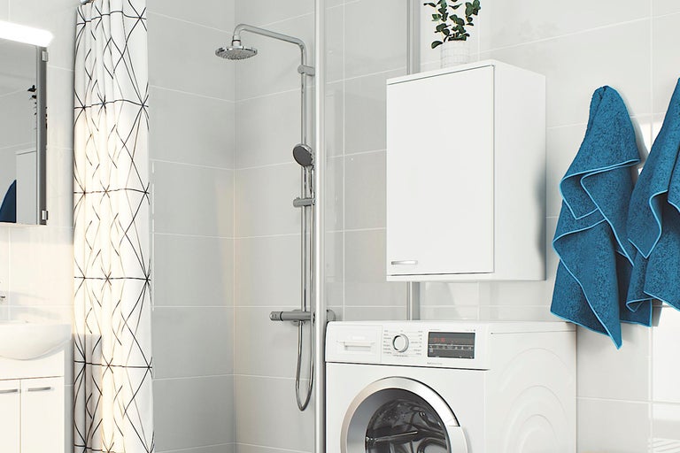 Ljust badrum med dusch, tvättmaskin och handfat