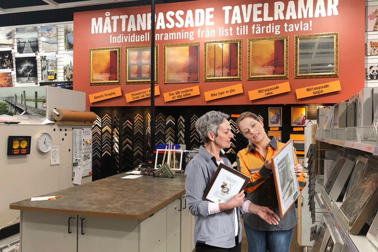 Kund och anställd i Hornbach-butiken som ger råd om fotoramar