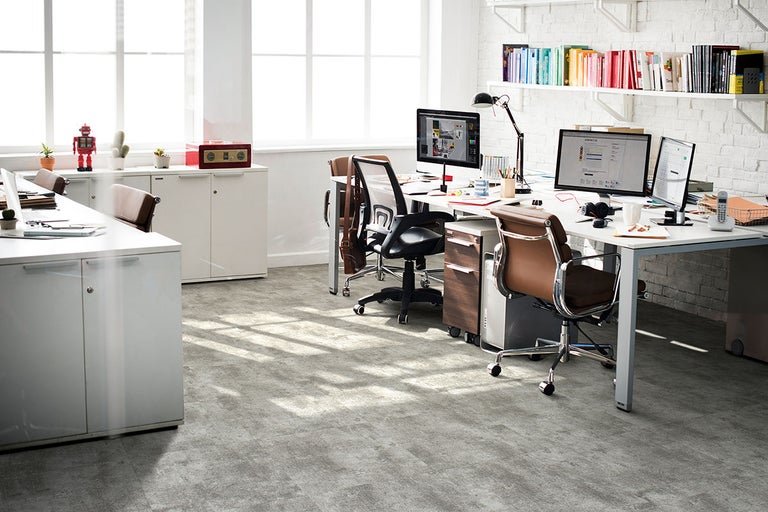 Kontorsrum med skrivbord, kontorsstolar och hyllor