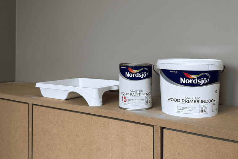 Nordsjö Träfärg inomhus och Trägrundfärg inomhus med färgtråg på en hylla