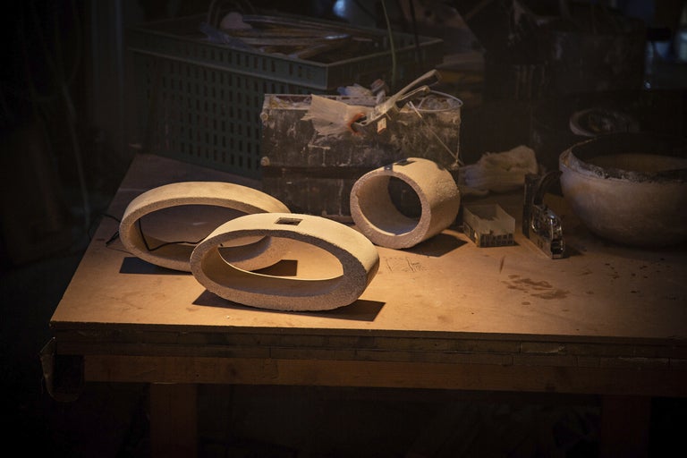 Verkstadsscen med bearbetade stenar på en arbetsbänk.