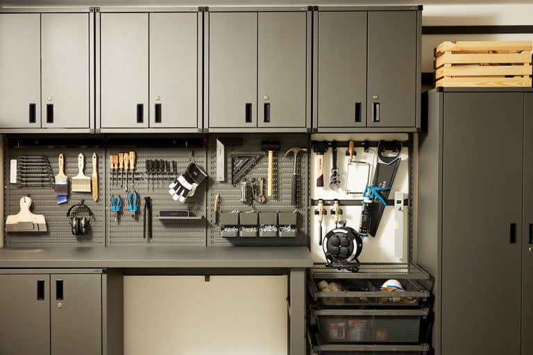 Verkstad med grå skåp, verktygsvägg och verktyg