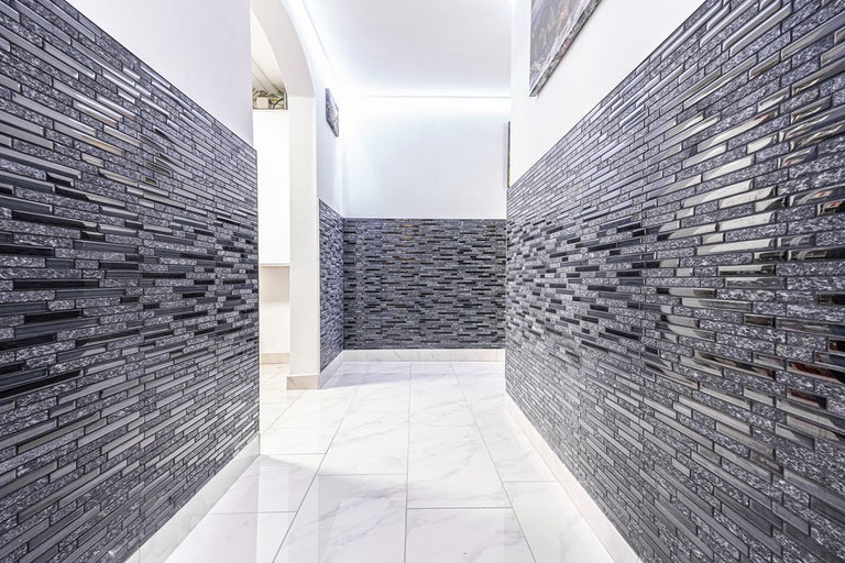 Hall med mosaikplattor på väggarna och klinkergolv