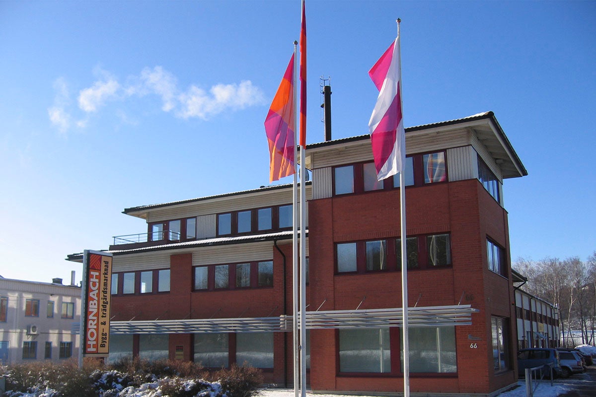 Hornbach byggmarknadsbyggnad med flaggor mot en blå himmel