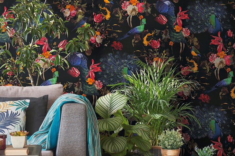Vardagsrum med soffa och blommig tapet med fågelmotiv