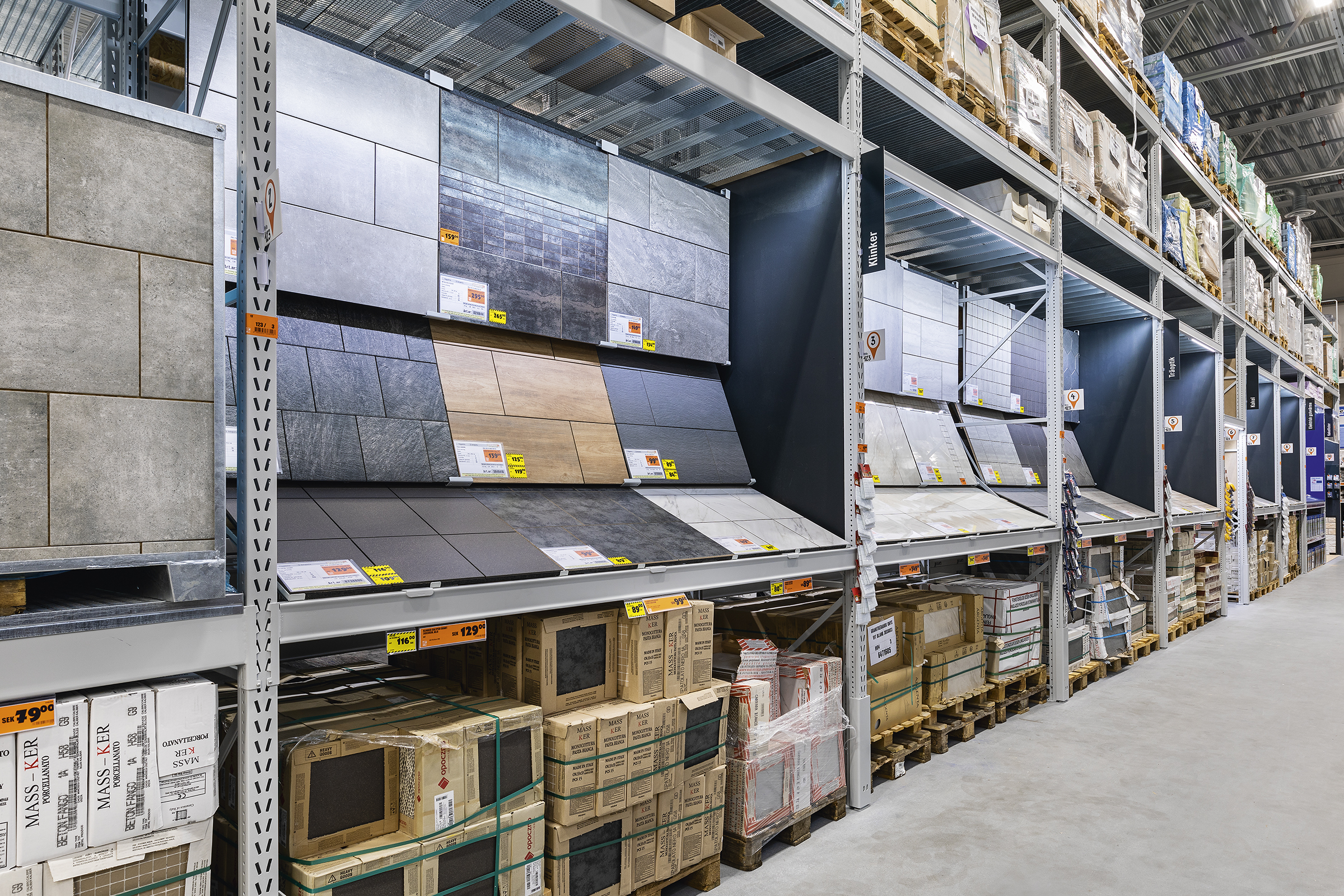 Hyllor med olika kakel och kakelförpackningar i en byggvaruhandel