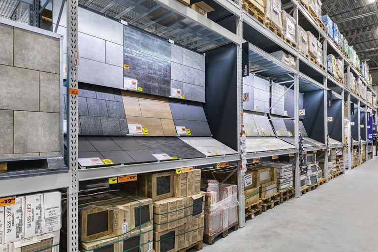 Hyllor med olika kakel och kakelförpackningar i en byggvaruhandel
