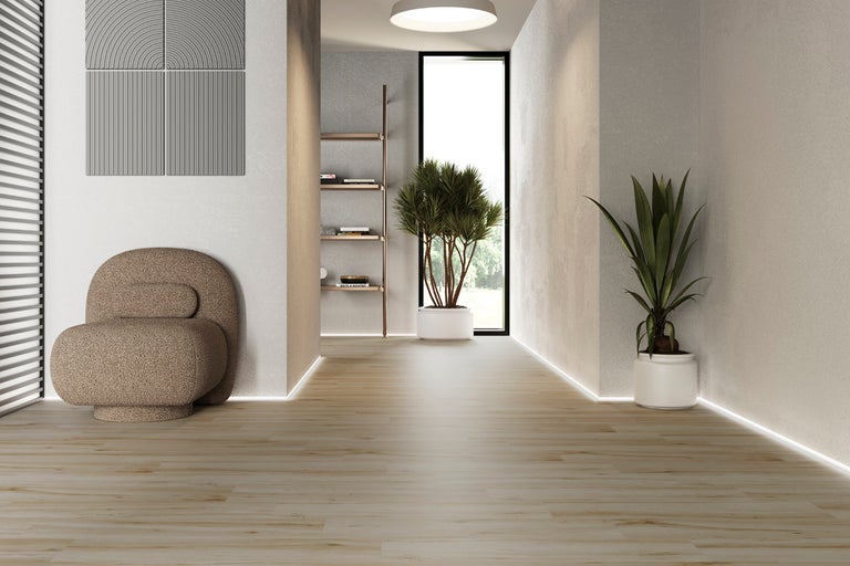 Ljust rum med fåtölj, hylla, växter och trägolv