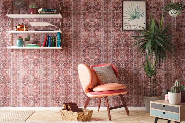 Dekorativt vardagsrum med mönstrad tapet, fåtölj och trähylla