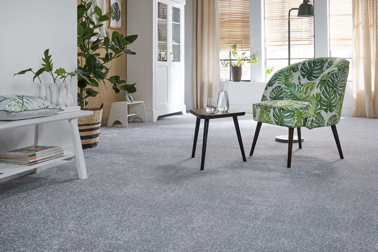 Vardagsrum med heltäckningsmatta, fåtölj och bord