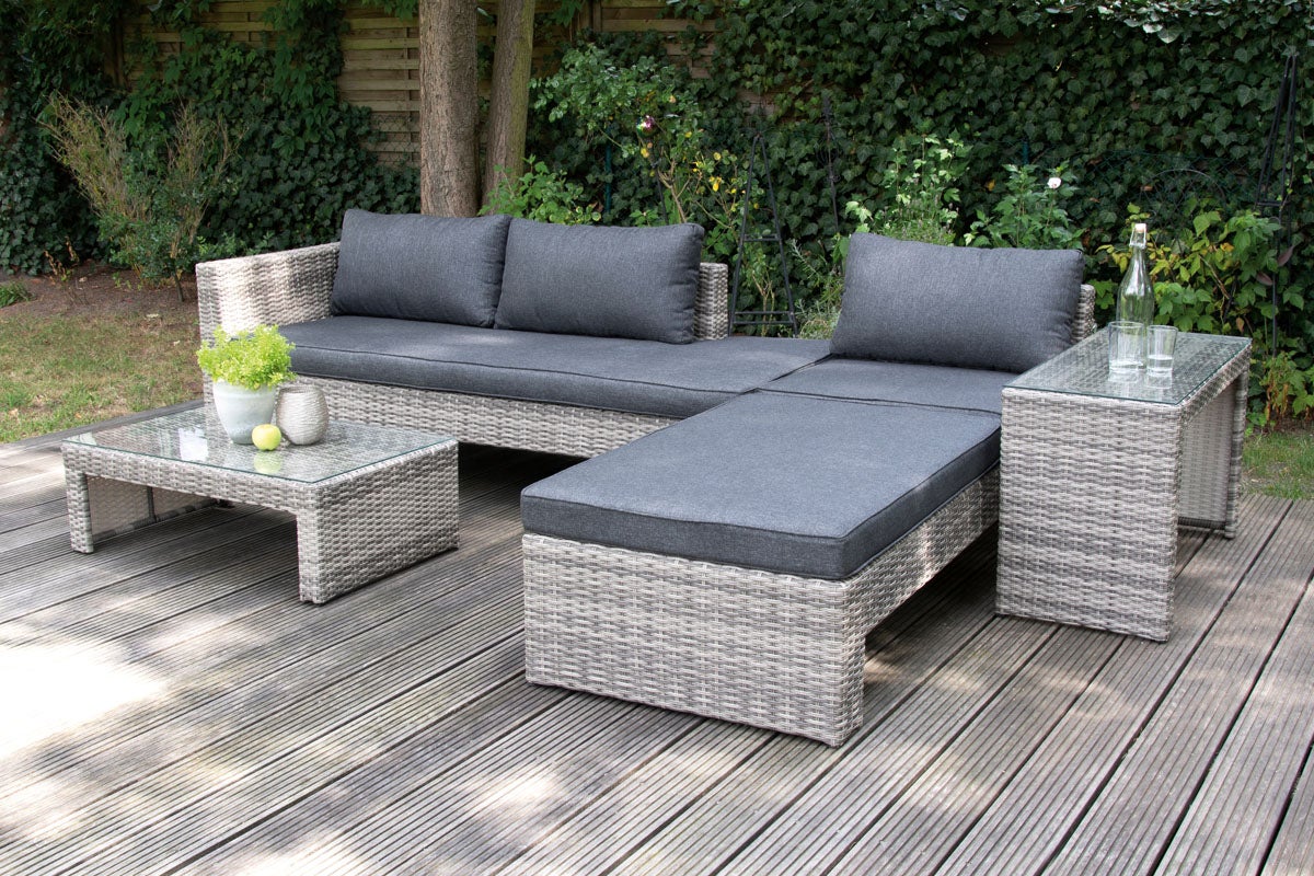 Utemöbelset med loungesoffa, solstol, bord och sidobord på en träaltan