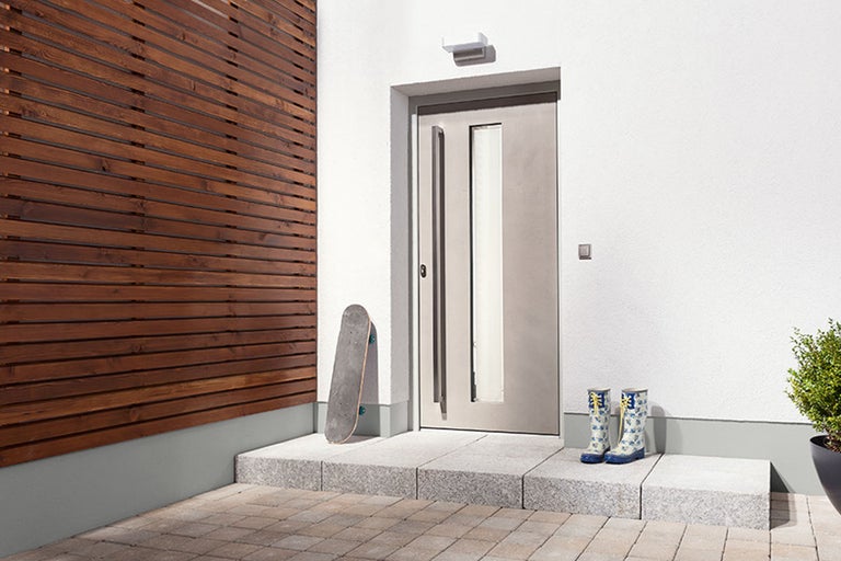 Scen med ytterdörr, träpanel, skateboard och gummistövlar