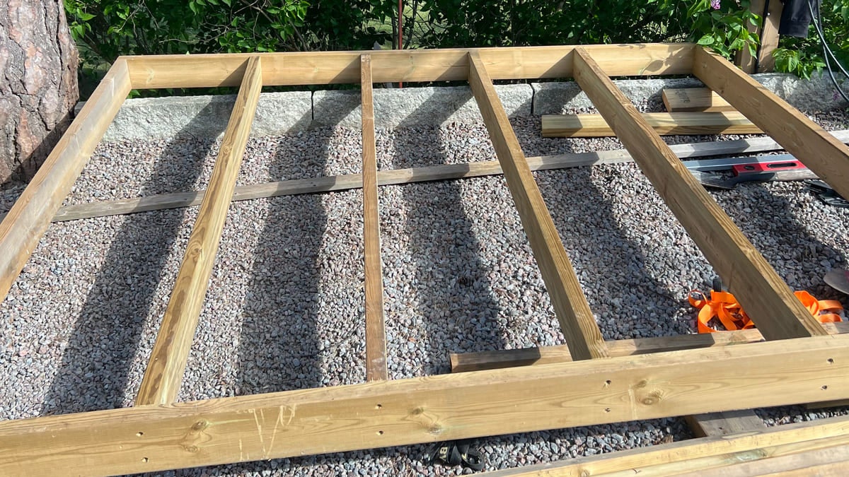 Träramskonstruktion på en bädd av grus för ett utomhusbyggprojekt