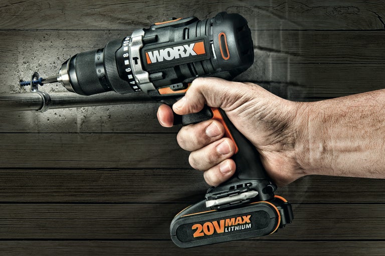 En person använder en sladdlös skruvdragare från Worx för att skruva in en skruv i en vägg.