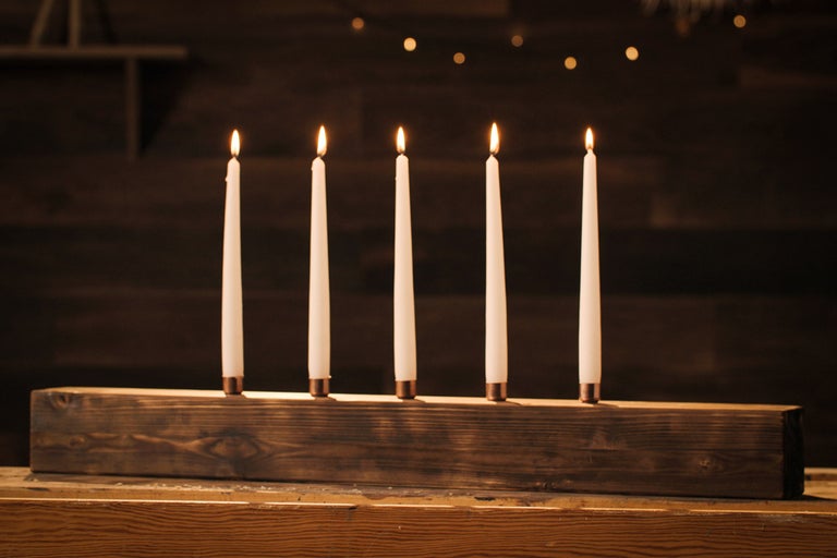 Fem ljus i en mörk trästake