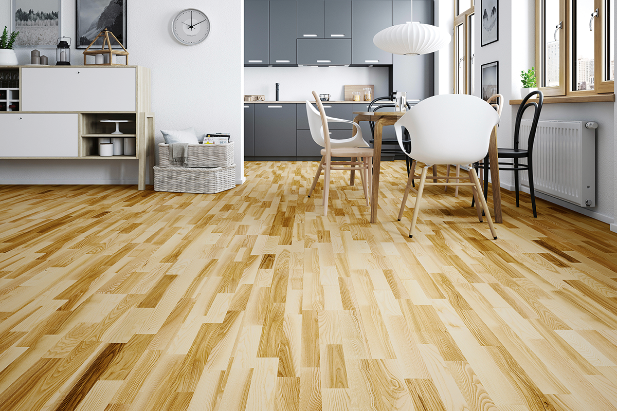 Träparkett i skeppsgolvsdesign i en ljus, modern matplats med intilliggande kök.