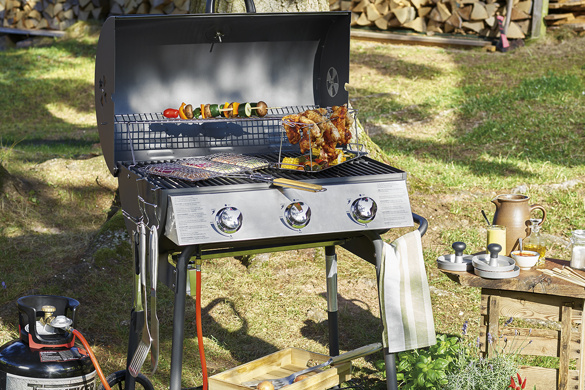 Gasolgrill med grillad mat utomhus