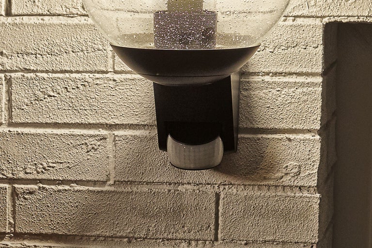 Utomhuslampa med rörelsesensor på en tegelvägg