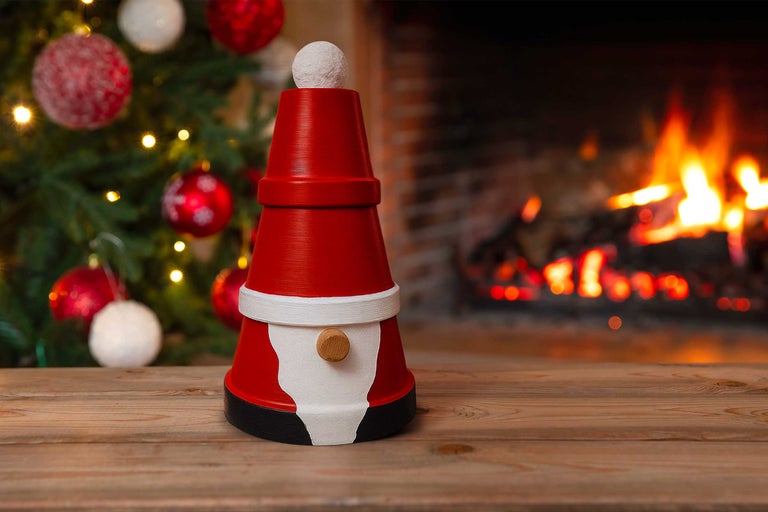 Juldekoration gjord av lerkrukor, på ett träbord