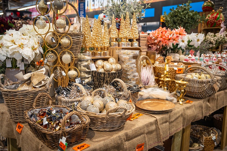 Utställning med juldekorationer, inklusive julgranskulor, prydnadsträd och blomsterarrangemang