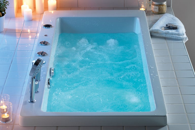 Badrumsscen med rektangulärt badkar fyllt med vatten