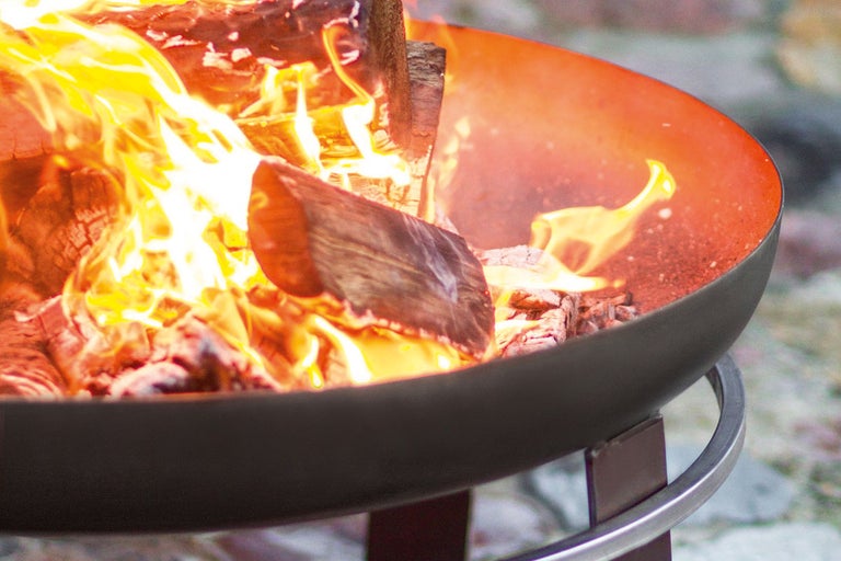Eld brinner i en eldfat på ett stativ.