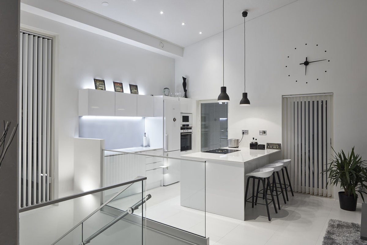 Ljust, modernt kök med köksö, barstolar och minimalistisk design
