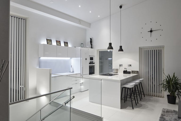 Ljust, modernt kök med köksö, barstolar och minimalistisk design