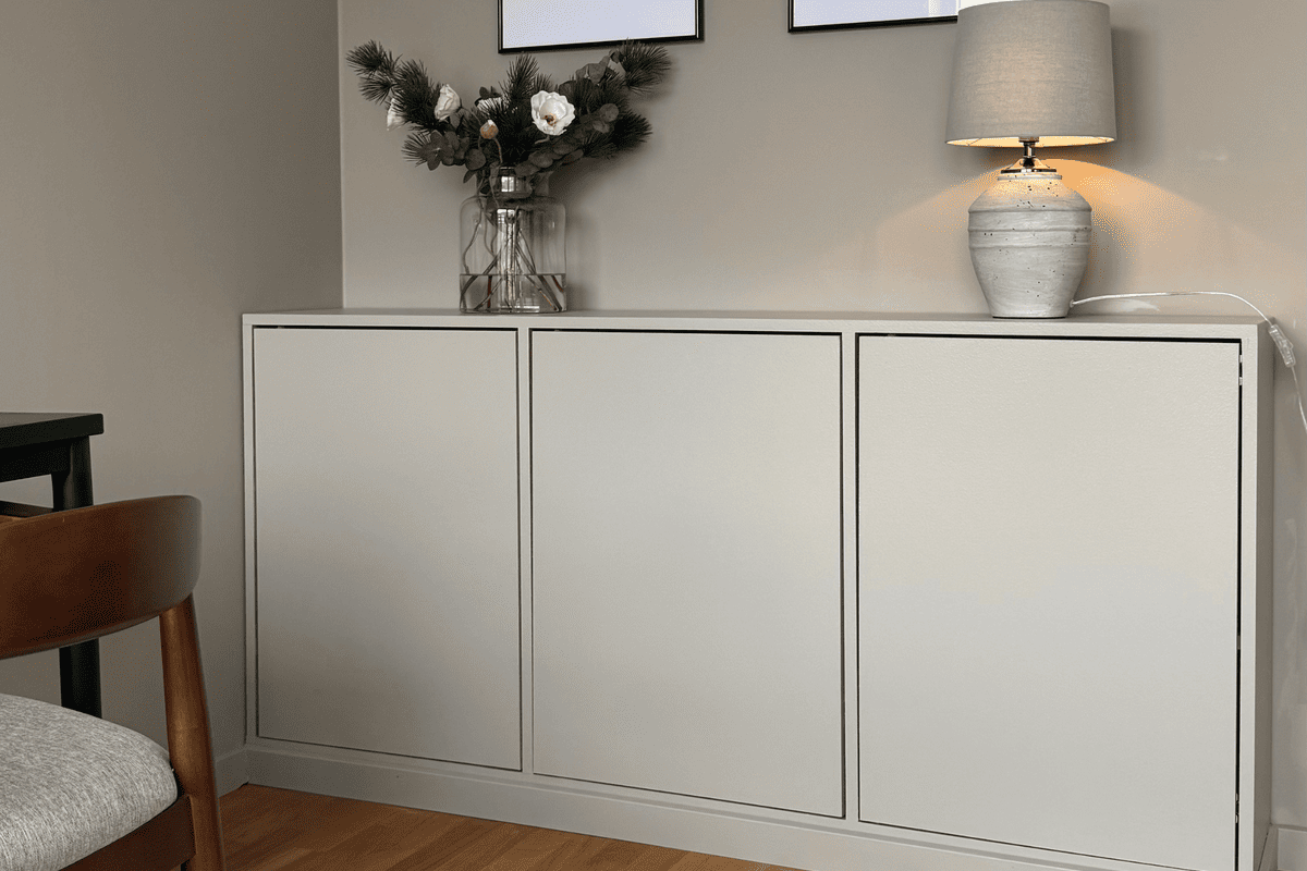 Modernt vardagsrum med en skänk, en lampa och dekoration