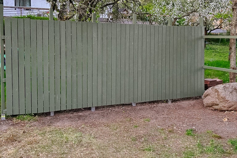 Trädgårdsutsikt med trästaket för tomtavgränsning