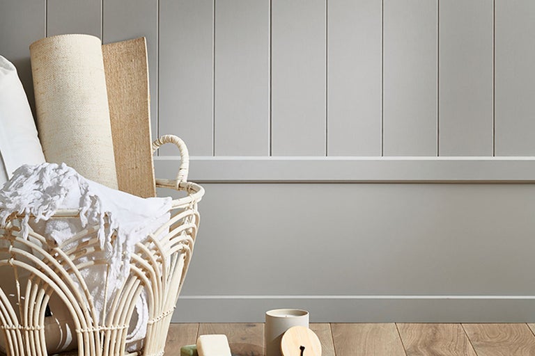 Dekorativ scen med korg, textilier och väggpaneler