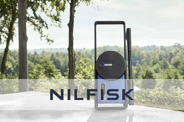 Nilfisk trädgårdsslangvagn med slang och sprutmunstycke framför trädlandskap
