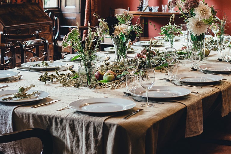 Dukat bord med porslin, glas, blommor och frukt som bordsdekoration