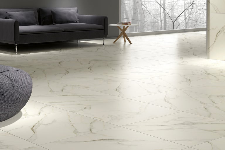 Ljust vardagsrum med golvplattor i marmorlook, soffa och sidobord