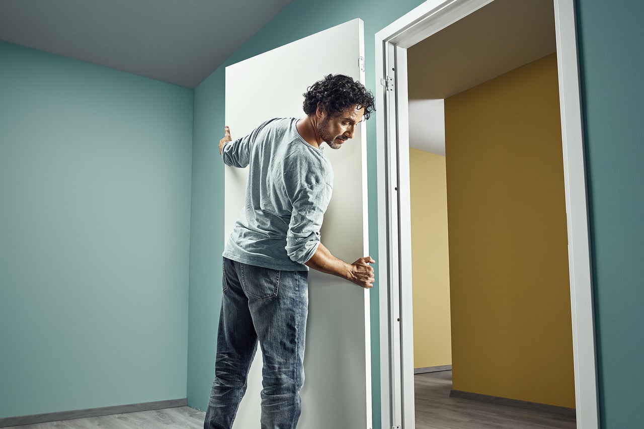 Man installerar innerdörr i ett rum