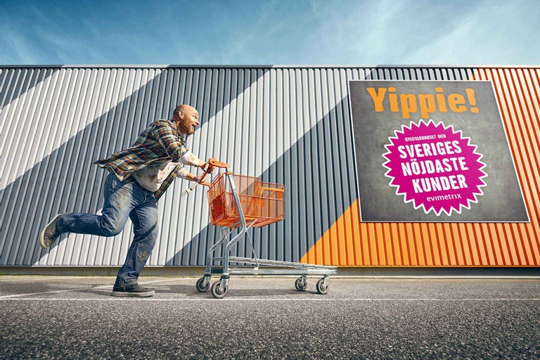 En man springer med en kundvagn framför ett Hornbach byggvaruhus.