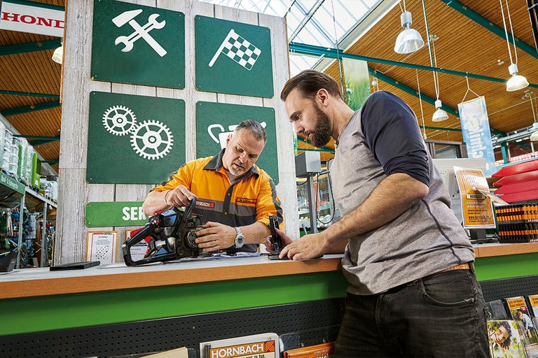En kund pratar med en Hornbach-anställd om en motorsåg.