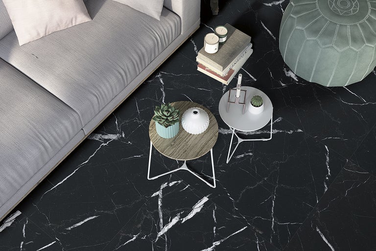 Vardagsrum med svart golv i marmorlook, soffa, soffbord och sittdyna