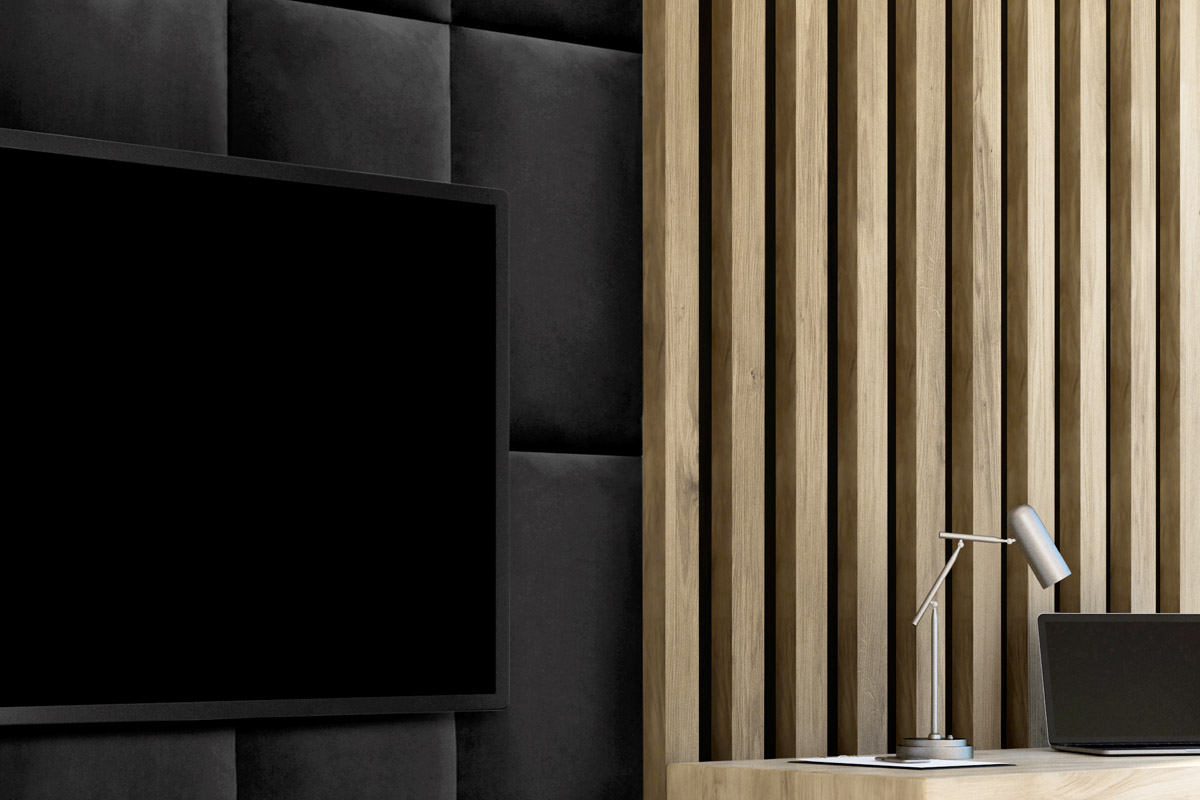 Detaljvy av en TV framför en vägg med träpaneler och klädsel
